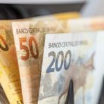 Cédulas de real brasileiro de R$20, R$50 e R$200 sobrepostas em leque, representando o valor líquido recebido na antecipação de precatório ou RPV pela LCbank