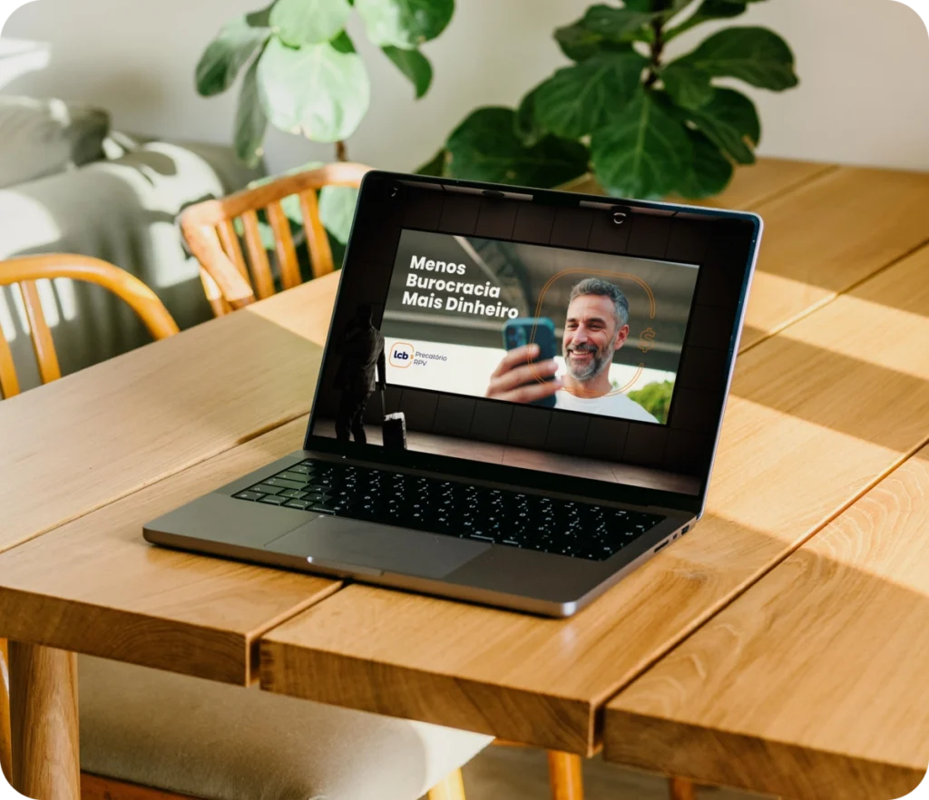 Laptop aberto exibindo vídeo sobre "Menos Burocracia Mais Dinheiro" do LCbank.